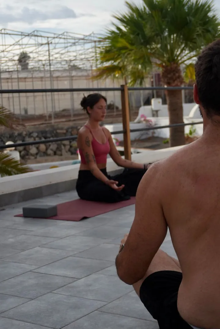 Nicole guida la meditazione seduta di un allievo sulla terrazza
